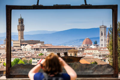 Woman with buildings in background