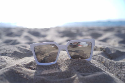 Close-up of sunglasses on beach