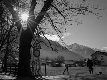 Man with dog walking by houses on sunny day