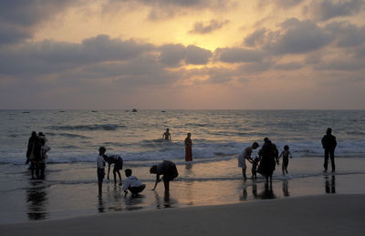 People at beach during sunset