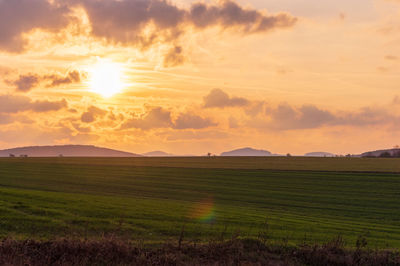 Scenic view of field against sky during sunset