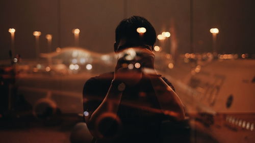 Close-up of man photographing illuminated city at night