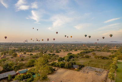 Hot air balloons flying over landscape against sky