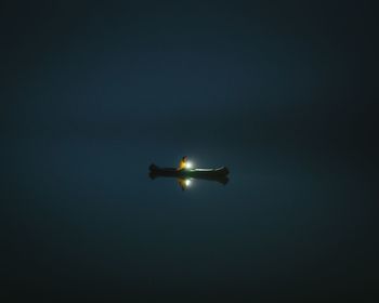 Low angle view of illuminated airplane against sky