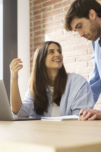 Young woman using mobile phone at office