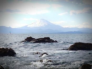 Scenic view of sea and mountains against sky