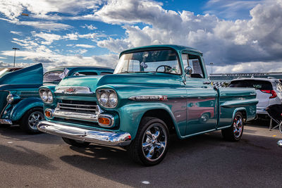 Vintage car on road against cloudy sky