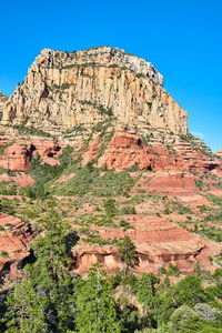 Rock formations on mountain against clear blue sky