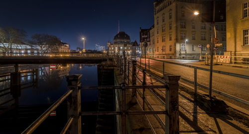 Illuminated bridge over river at night