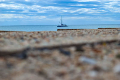 Sailboat on sea shore against sky