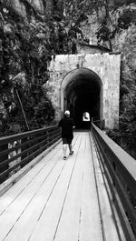 Rear view of man walking on bridge