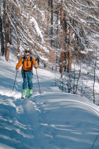 Full length of woman skiing on snow covered mountain