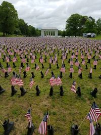 Various flags on cemetery against sky