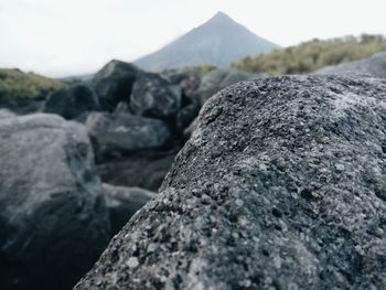 Close-up of rock on mountain against sky