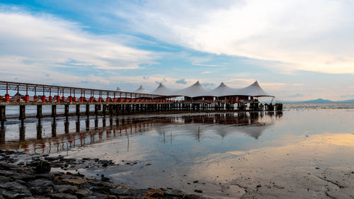 Pier on beach against sky