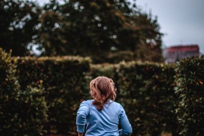 Rear view of woman running in maze