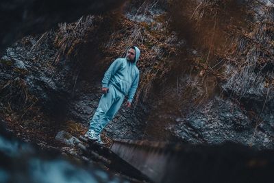 Man standing on rock in forest