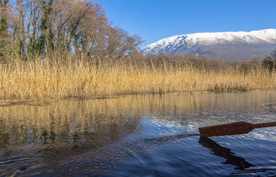 Scenic view of lake by snowcapped mountains against sky