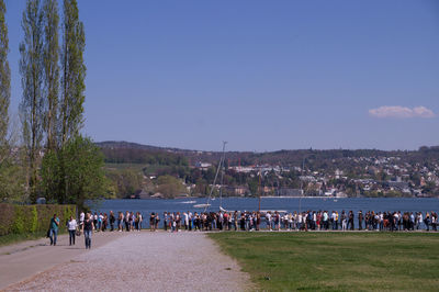 People at beach against clear sky