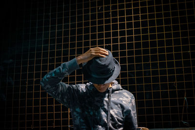 Rear view of man standing against brick wall