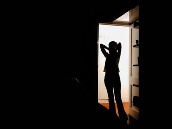 Silhouette woman standing at doorway