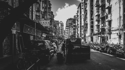 Vehicles on road amidst buildings in town