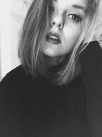 Close-up portrait of smiling young woman at home