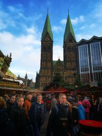 Group of people in front of buildings against sky