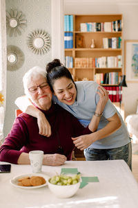 Happy friends sitting on table