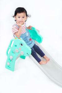 Portrait of boy with toy against white background