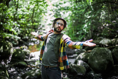 Full length of young man standing in forest