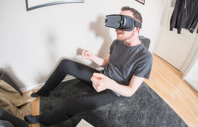 Man using virtual reality simulator while sitting at home