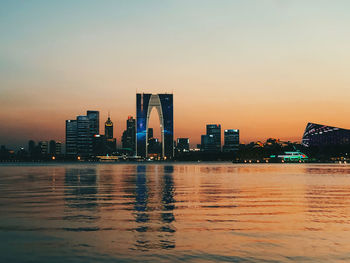 River by illuminated buildings against sky during sunset suzhou center, landmark building, skyline