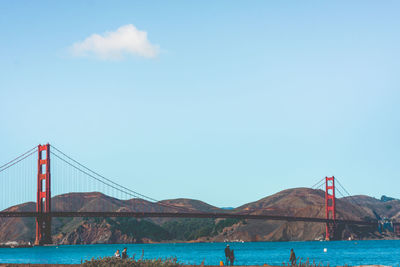 View of suspension bridge over sea against sky