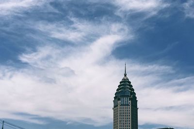 Low angle view of building against cloudy sky