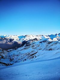 Scenic view of snowcapped mountains against clear blue sky