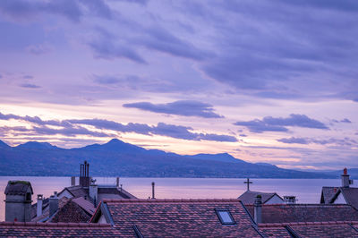 Scenic view of sea and buildings against sky during sunset
