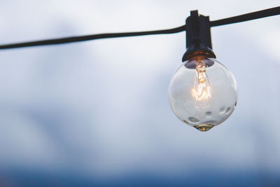 Low angle view of wet light bulb against sky at dusk