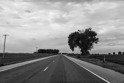 Road by trees against sky