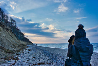 Rear view of woman looking at sea against sky