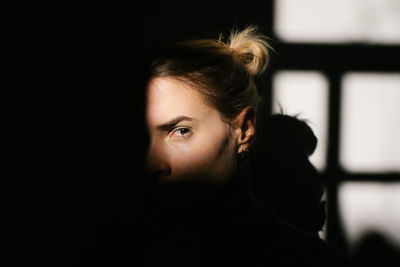 Portrait of young woman against wall