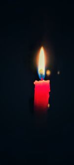 Close-up of lit candle in the dark