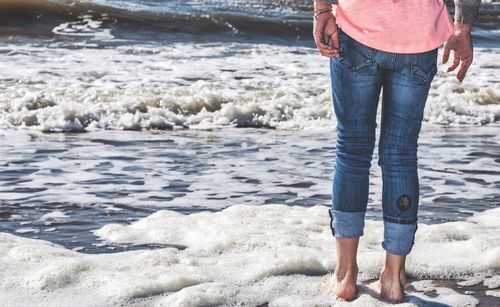 Low section of woman standing on beach