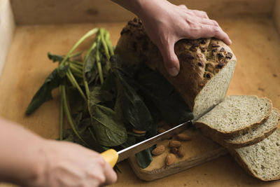 Close-up of person slicing bread