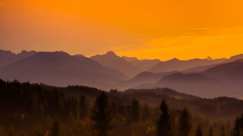 Scenic view of silhouette mountains against orange sky