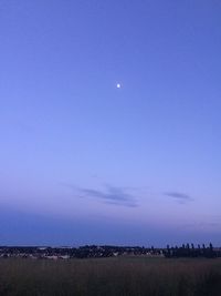 Scenic view of field against clear blue sky at night