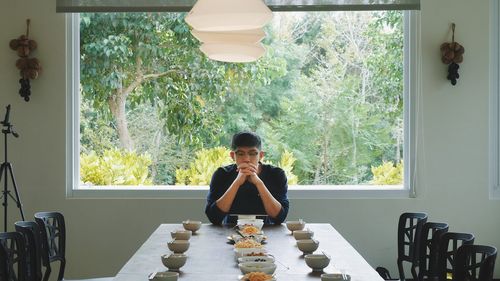 Portrait of woman sitting on table at home