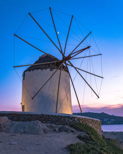 Traditional windmill against sky at sunset