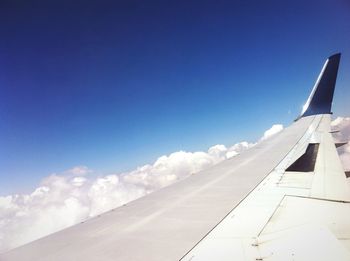 Cropped image of airplane against blue sky