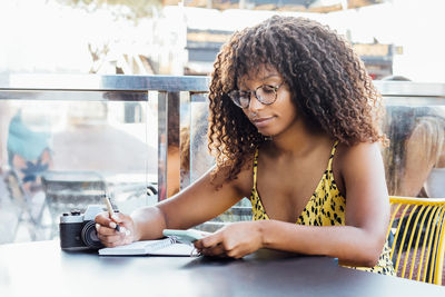 Portrait of a young woman sitting on table